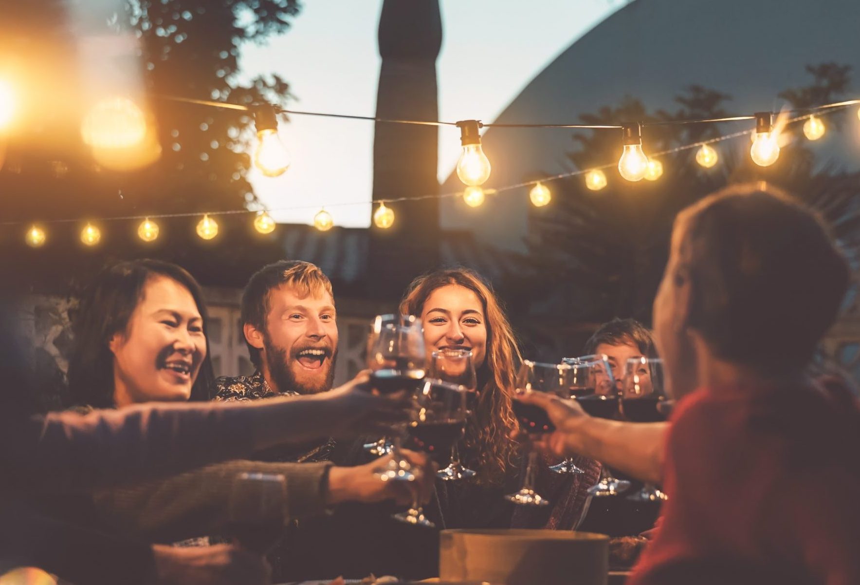 A group of friends celebrating with seamless wine toasts at a dinner party.
