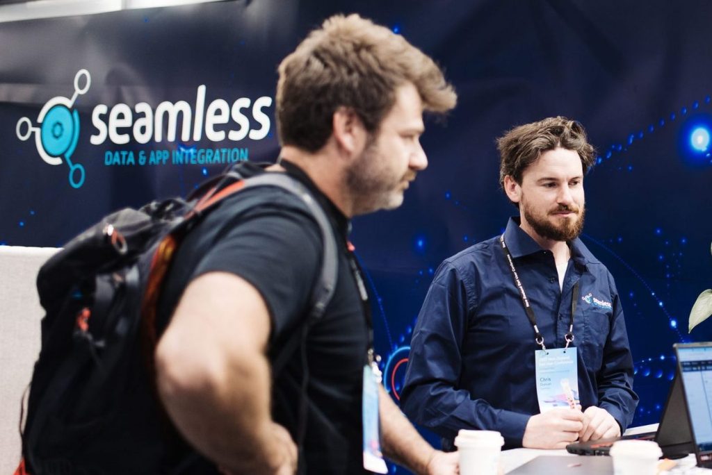 Two men showcasing highlights at a booth during the NZ Esri User Conference 2022.